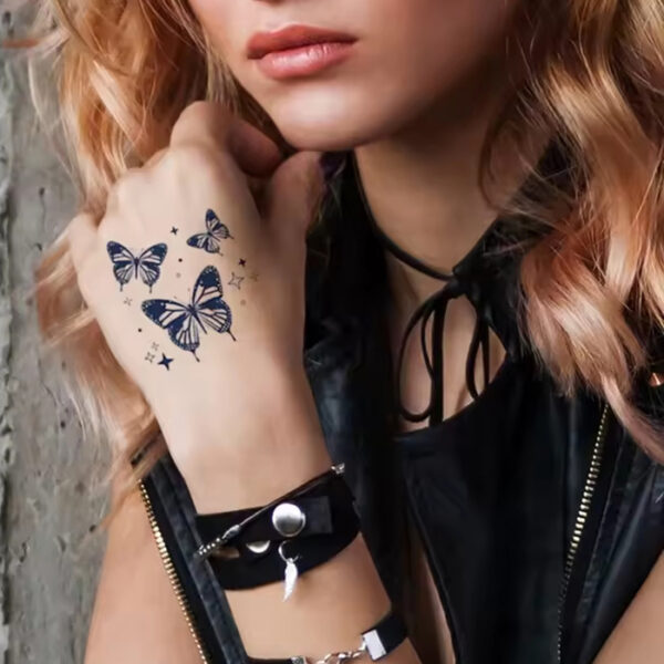 Zarte Schmetterlingsmotive als temporäre Tattoos auf Frauenhand